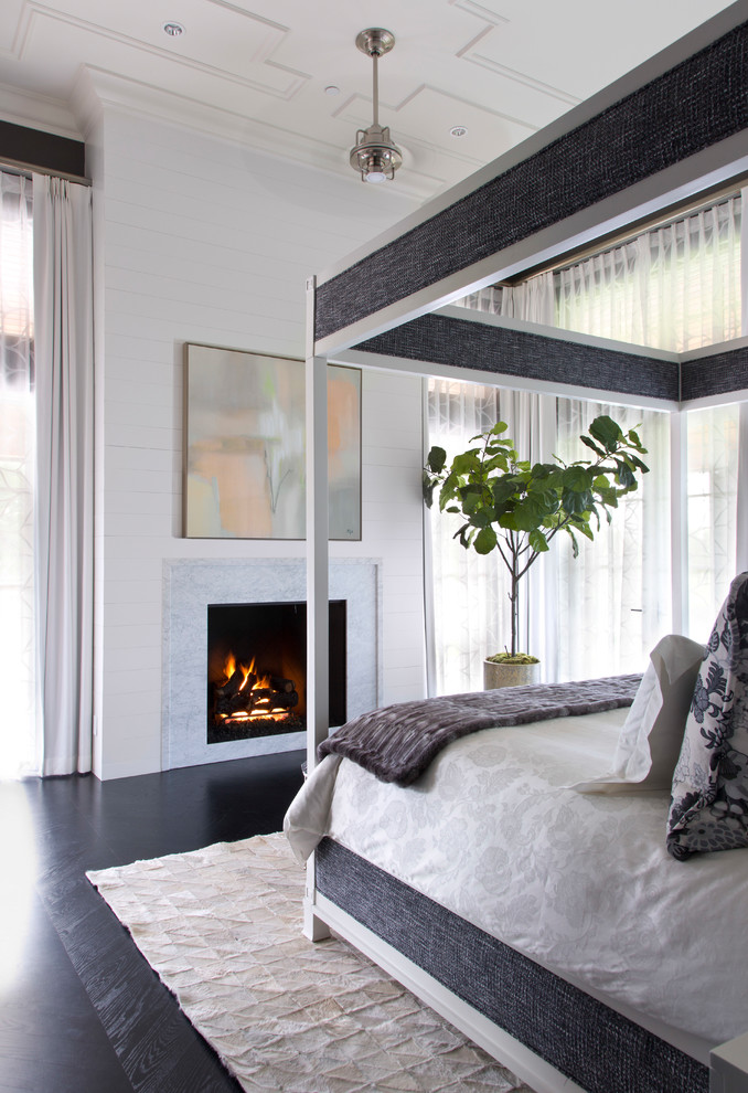 Modelo de dormitorio tradicional renovado con paredes blancas, suelo de madera oscura, todas las chimeneas y suelo negro