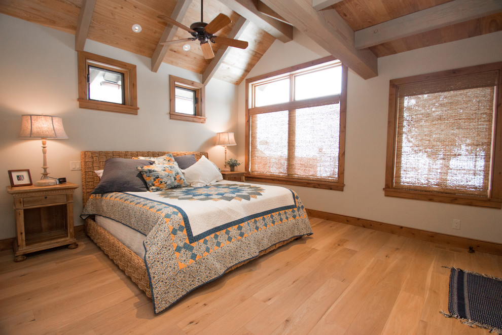 Imagen de dormitorio principal rústico grande con paredes beige y suelo de madera clara