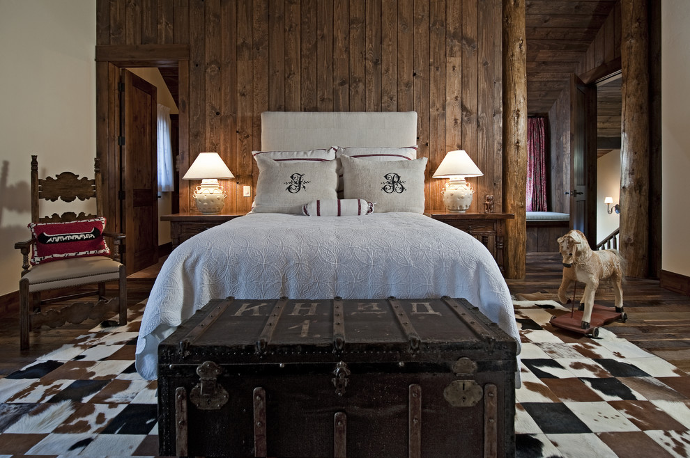 Imagen de dormitorio rural con paredes beige y suelo de madera oscura