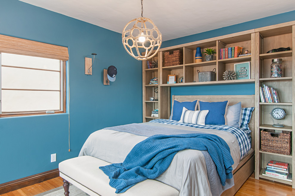 Ejemplo de dormitorio marinero sin chimenea con paredes azules y suelo de madera en tonos medios