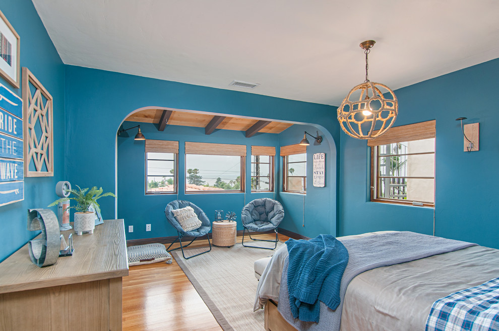 Idee per una camera da letto stile marinaro con pareti blu, nessun camino e pavimento in legno massello medio