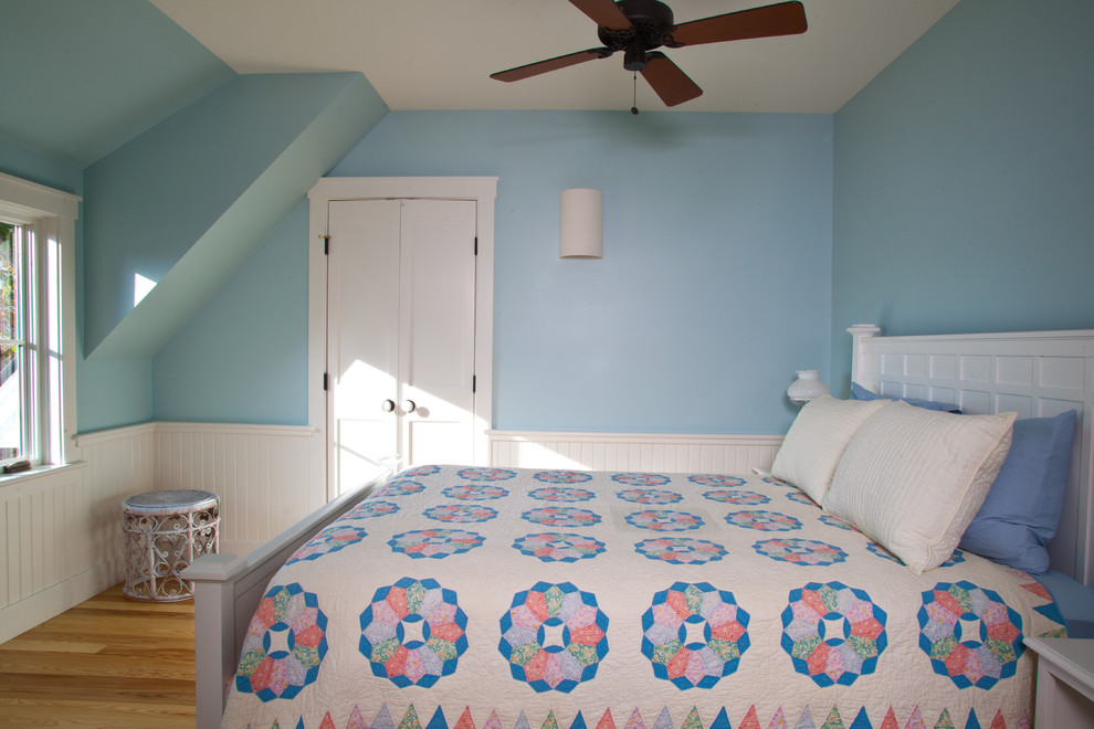 Réalisation d'une petite chambre d'amis design avec un mur bleu et parquet clair.