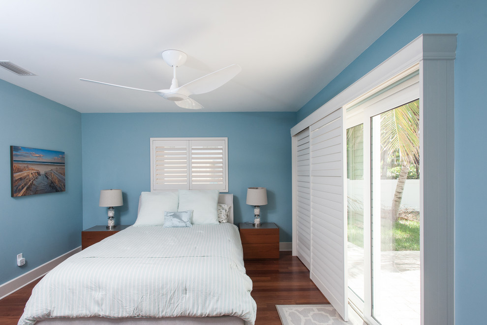 Foto de habitación de invitados marinera de tamaño medio sin chimenea con paredes azules, suelo de madera en tonos medios y suelo marrón