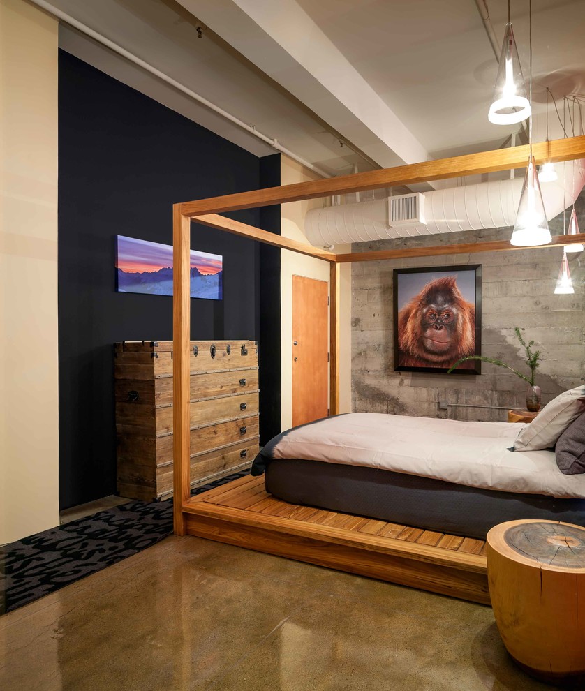 Contemporary bedroom in Los Angeles with black walls and concrete flooring.