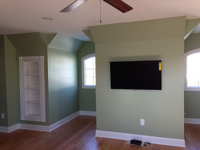 Aménagement d'une chambre contemporaine avec un mur vert et un sol en bois brun.