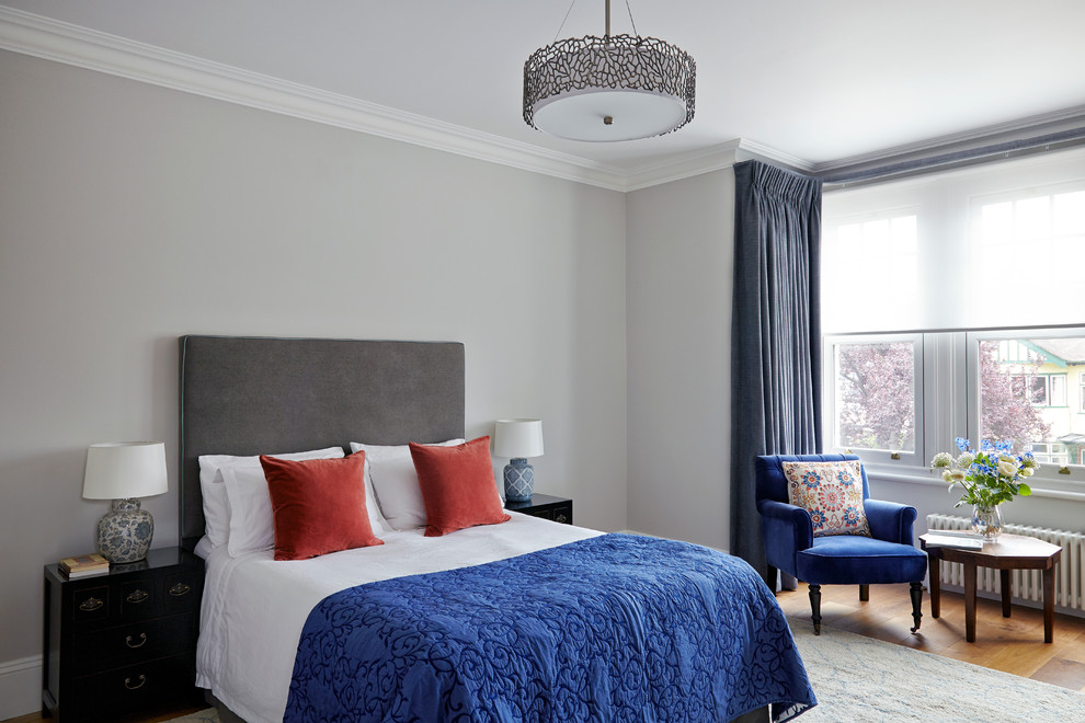 This is an example of a large classic master and grey and silver bedroom in London with grey walls, medium hardwood flooring and no fireplace.