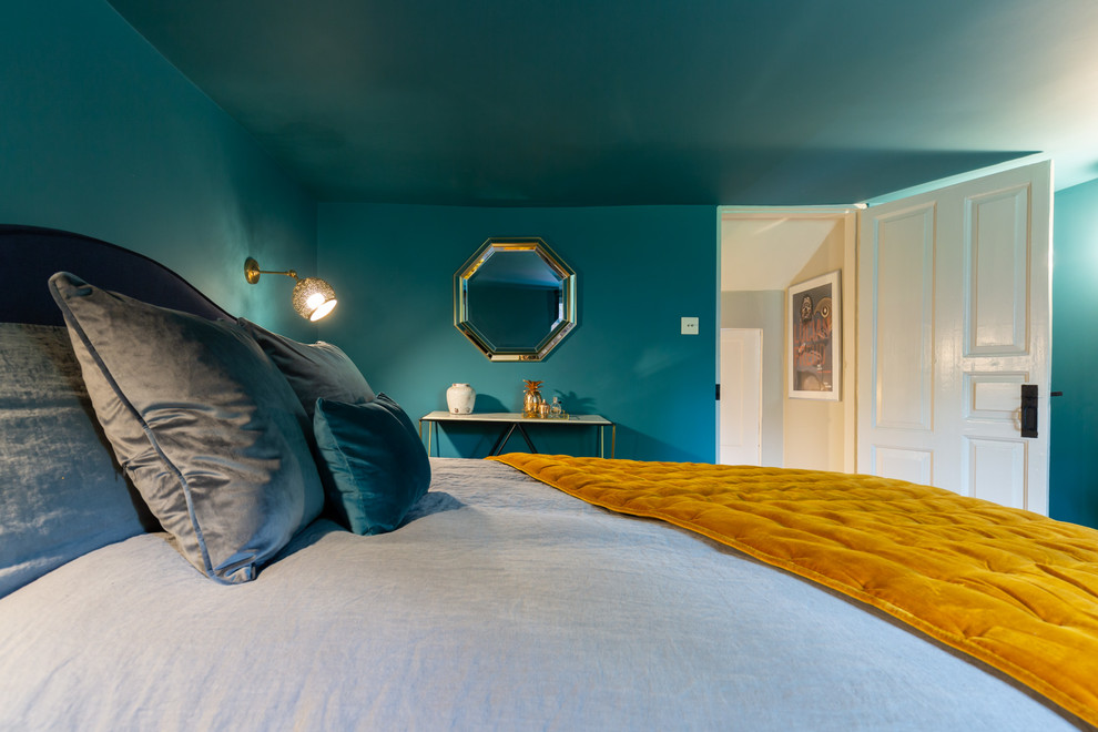 Kleines Stilmix Hauptschlafzimmer ohne Kamin mit blauer Wandfarbe, Laminat und braunem Boden in Sonstige