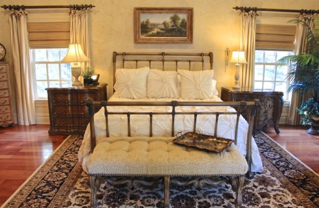 Geräumiges Klassisches Schlafzimmer mit beiger Wandfarbe, braunem Holzboden und braunem Boden in New York