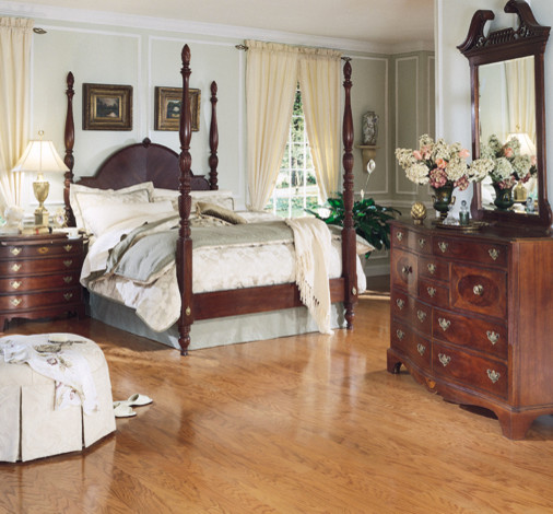 Modelo de dormitorio principal tradicional sin chimenea con paredes beige, suelo de madera clara y suelo beige