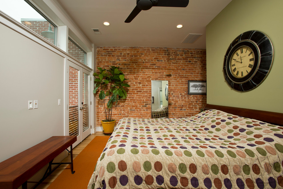 Réalisation d'une chambre parentale design de taille moyenne avec un mur vert, un sol en bois brun et aucune cheminée.