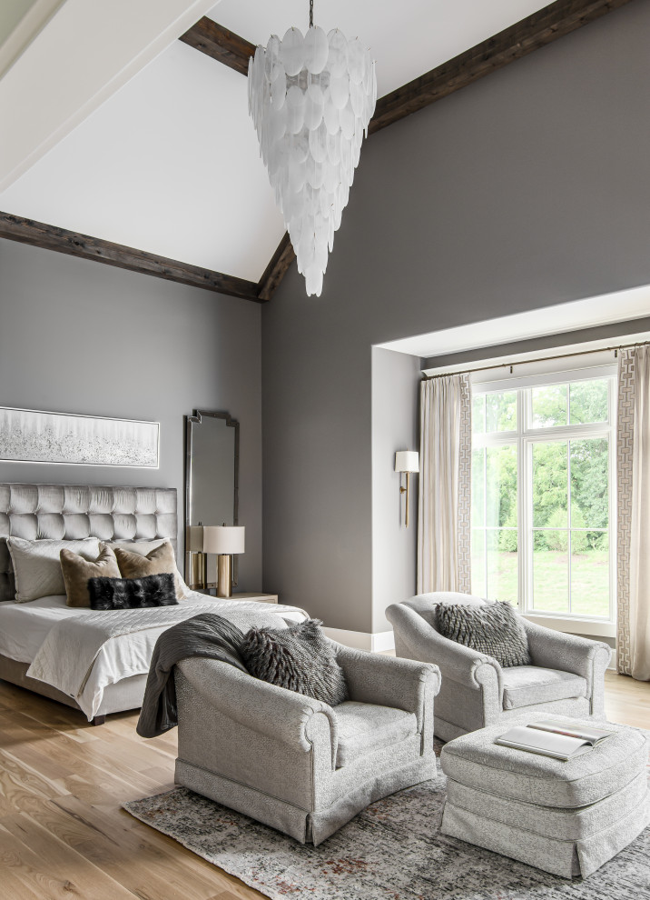 Aménagement d'une grande chambre parentale classique avec un mur gris, un sol en bois brun et un plafond voûté.