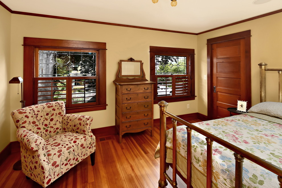 Mittelgroßes Klassisches Gästezimmer ohne Kamin mit gelber Wandfarbe, braunem Holzboden und braunem Boden in Seattle