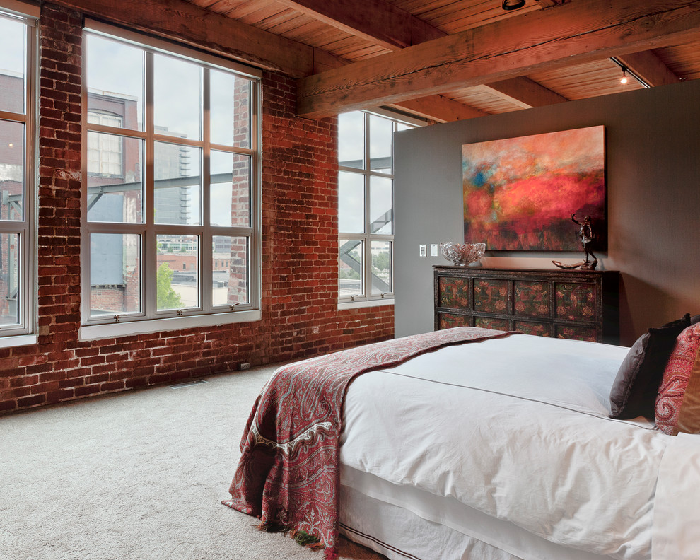 This is an example of a bedroom in Columbus with brown walls and carpet.