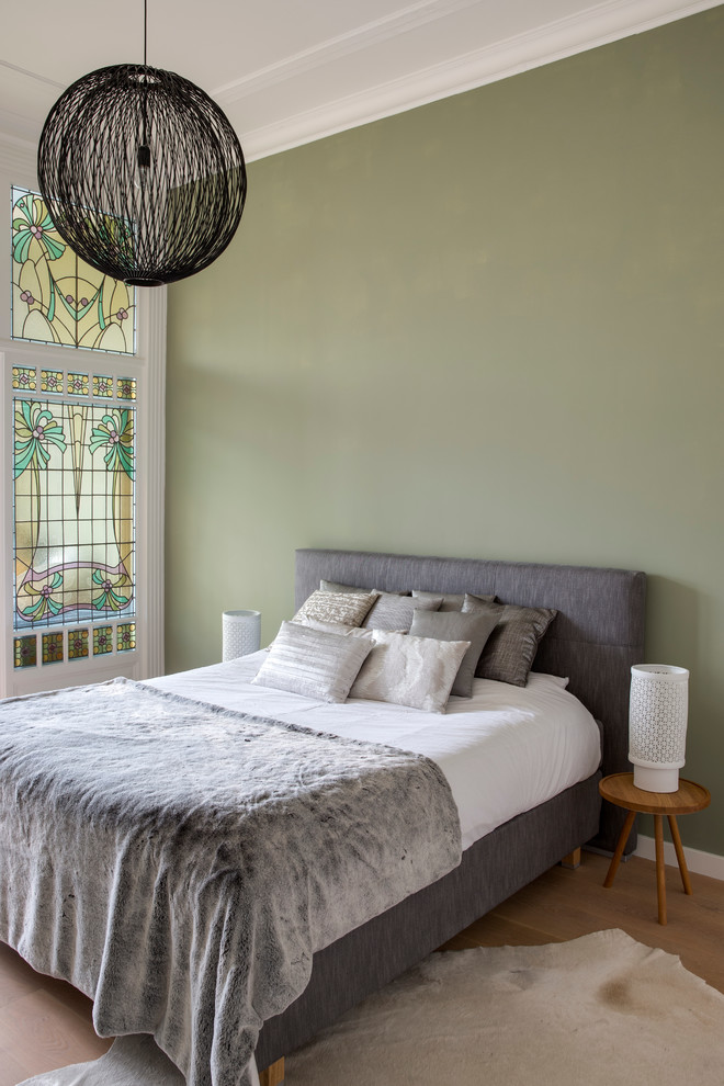 Idéer för ett modernt sovrum, med gröna väggar och ljust trägolv