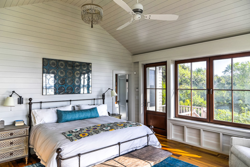 Cette image montre une chambre parentale marine avec un mur blanc et un sol en bois brun.