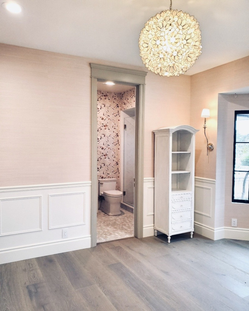Example of a large transitional medium tone wood floor, gray floor and wallpaper bedroom design in San Francisco with pink walls