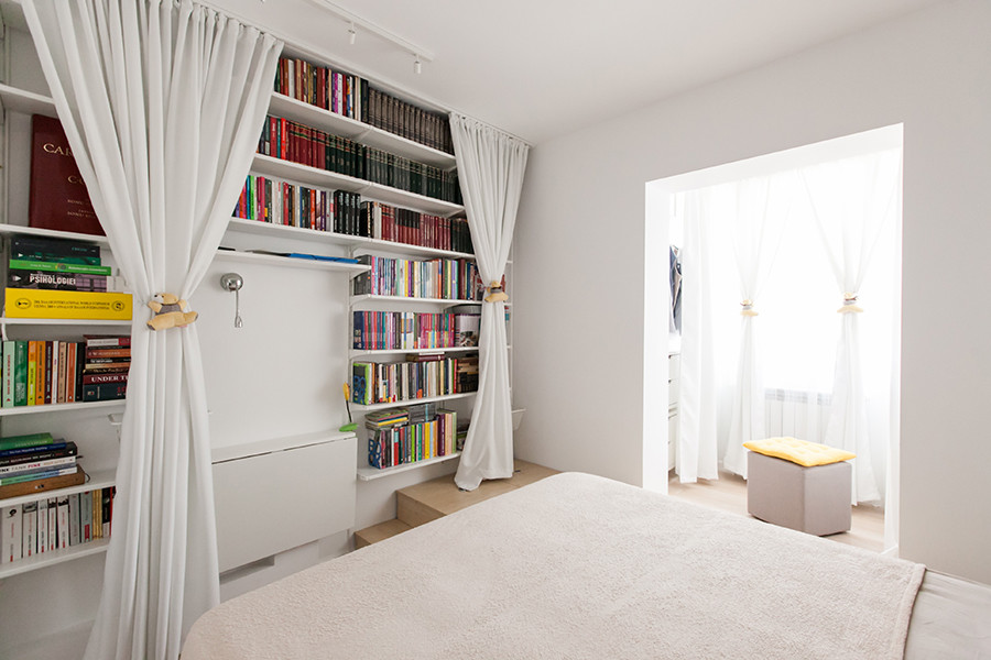 Kleines Modernes Hauptschlafzimmer mit weißer Wandfarbe und Sperrholzboden in Sonstige