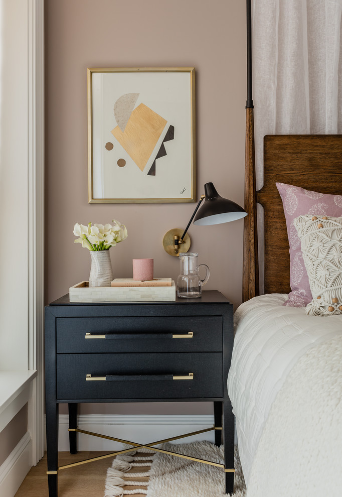 Example of a transitional medium tone wood floor and brown floor bedroom design in Boston with pink walls