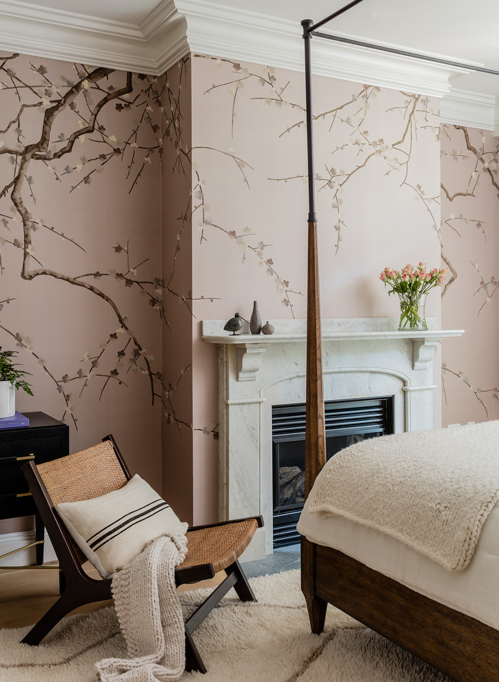 Immagine di una camera da letto tradizionale con pareti rosa, pavimento in legno massello medio, camino classico e pavimento marrone