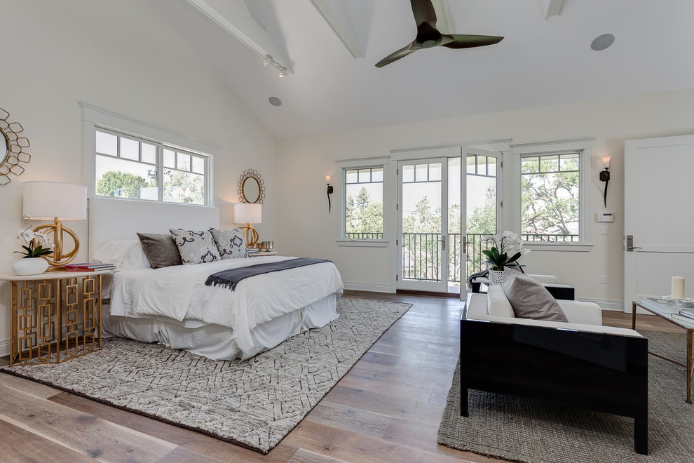 Large transitional master medium tone wood floor bedroom photo in Los Angeles with white walls