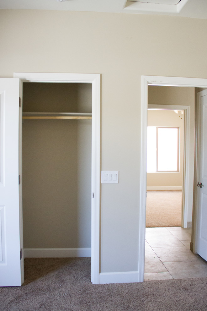 Immagine di una camera degli ospiti chic di medie dimensioni con pareti beige, moquette, nessun camino e pavimento marrone