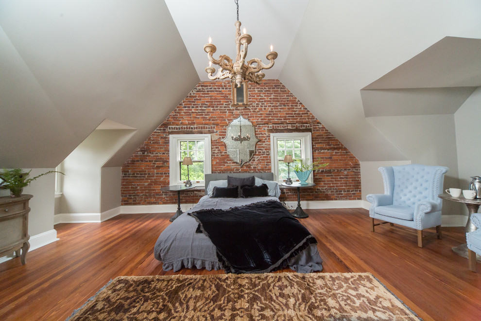 Immagine di una grande camera matrimoniale classica con pareti grigie e pavimento in legno massello medio