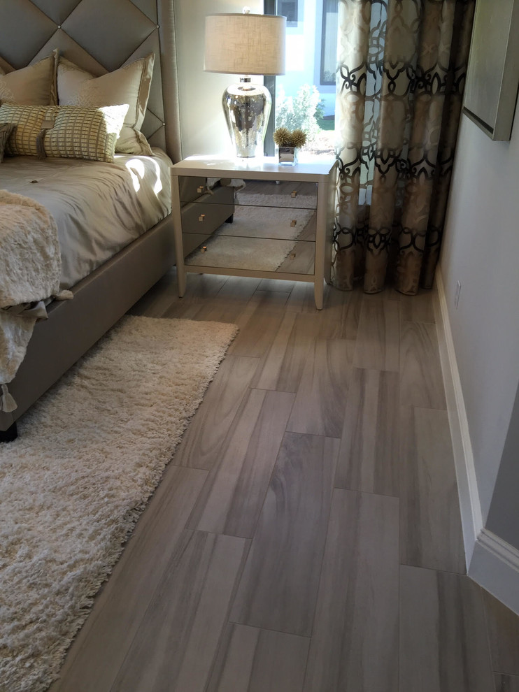 Inspiration for a large contemporary master light wood floor and beige floor bedroom remodel in Miami with gray walls