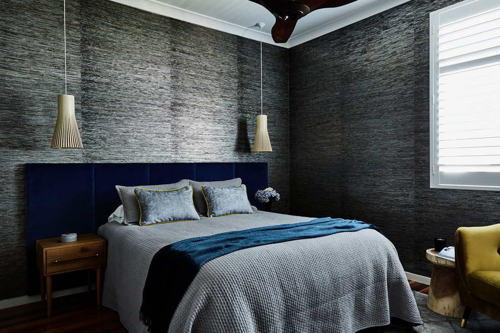 Modelo de dormitorio contemporáneo con paredes grises, suelo de madera en tonos medios y suelo marrón