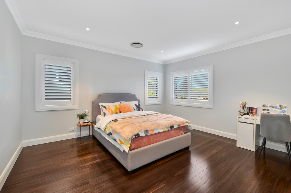 Design ideas for a large contemporary guest bedroom in Sydney with grey walls, no fireplace, brown floors and dark hardwood flooring.