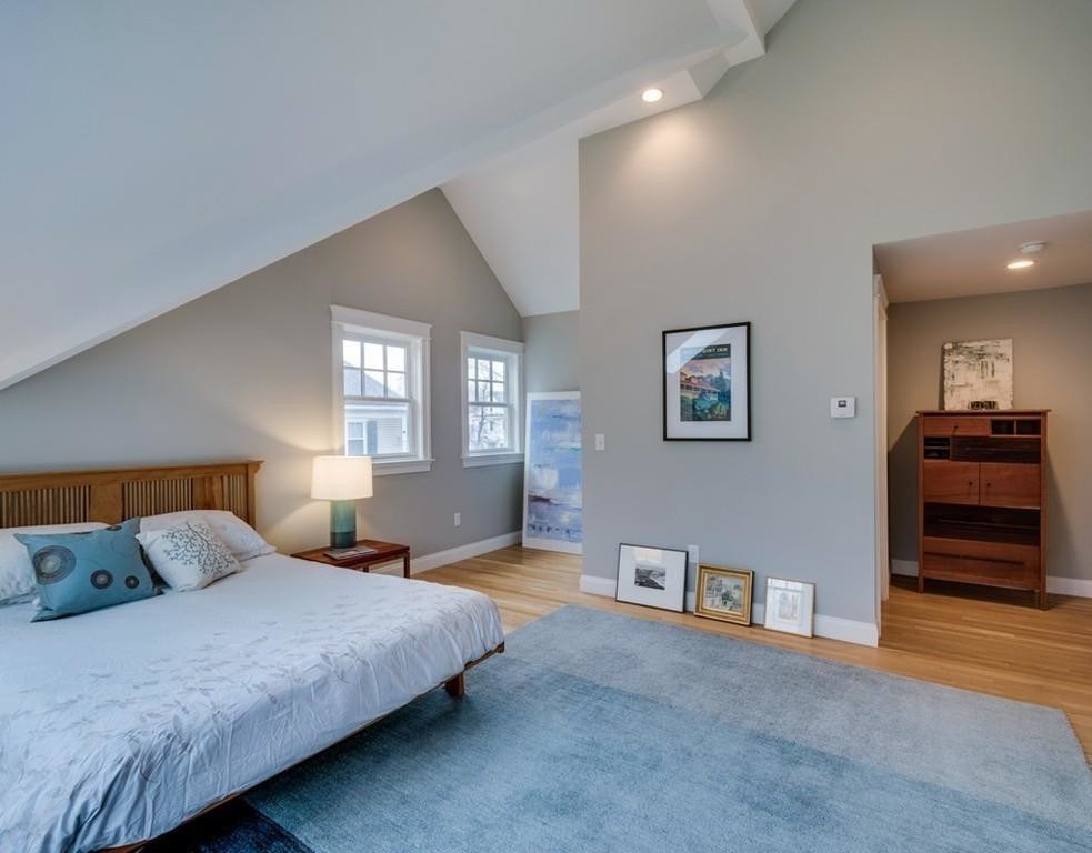 Medium sized scandinavian master bedroom in Boston with grey walls and light hardwood flooring.