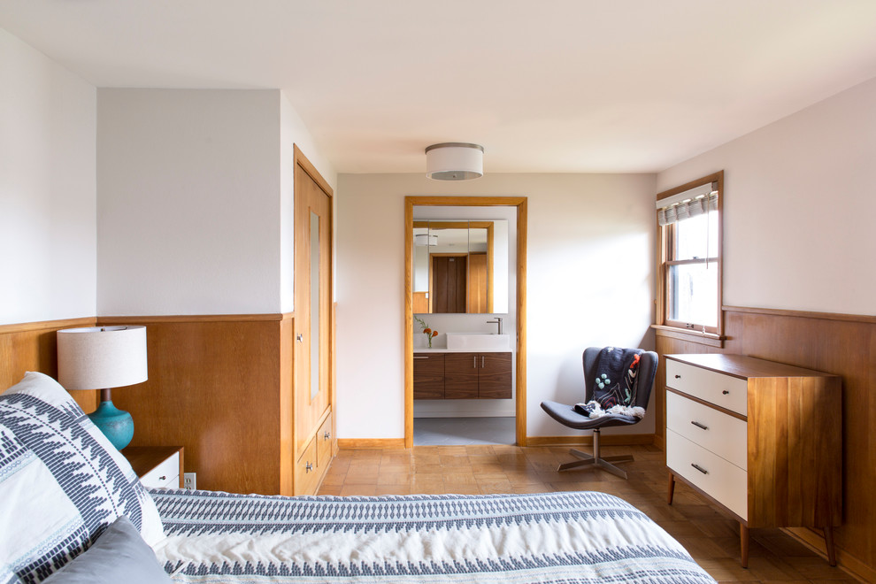 Small midcentury master bedroom in Portland with white walls and medium hardwood flooring.