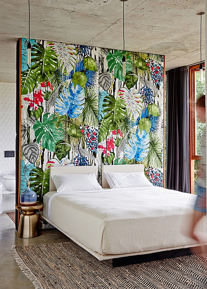 Esempio di una camera da letto tropicale con pareti multicolore e pavimento in cemento