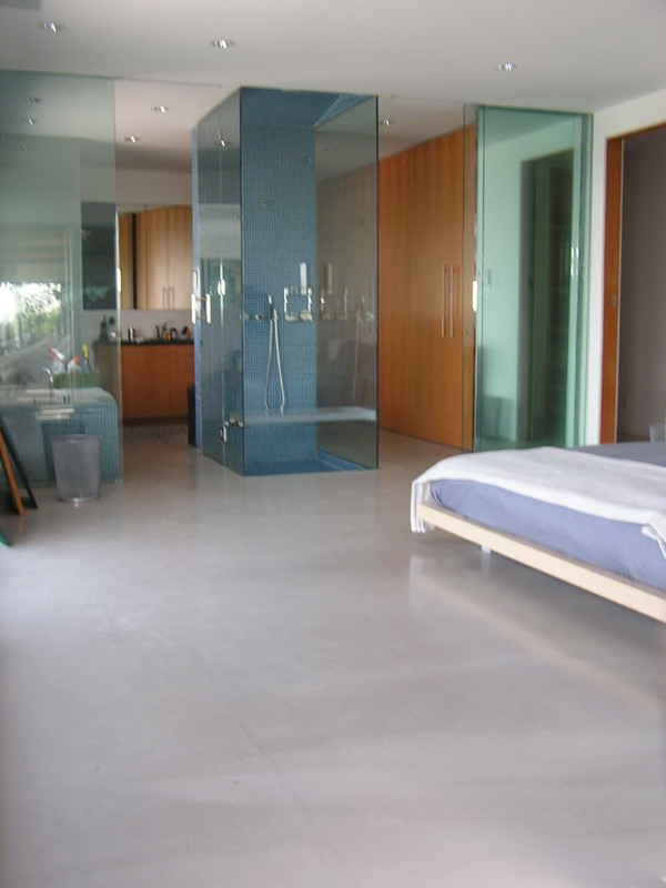 Immagine di una camera da letto contemporanea con pavimento in cemento