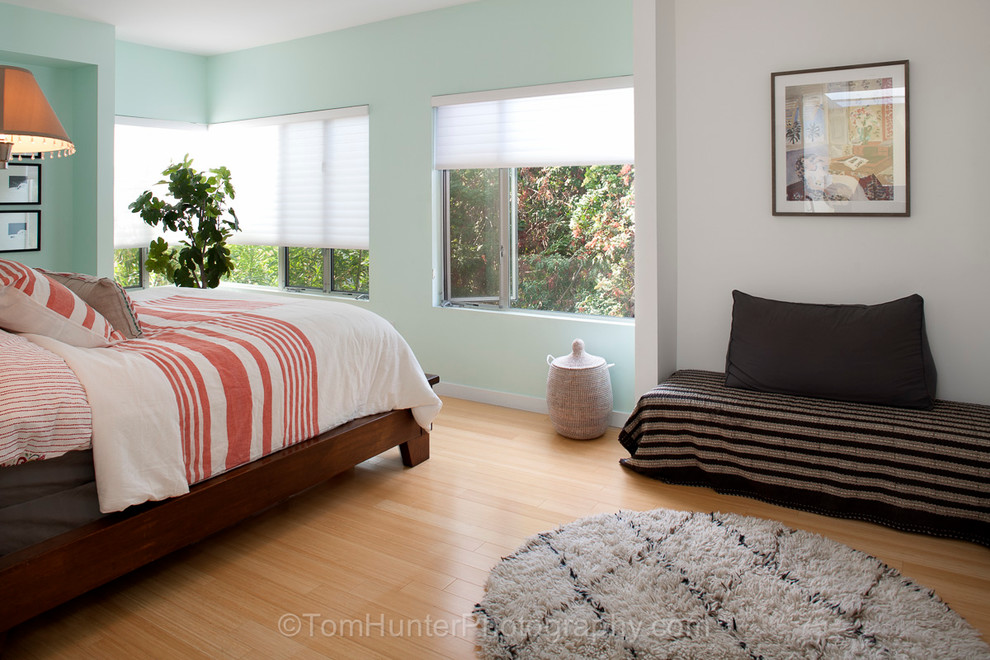 На фото: большая хозяйская спальня в современном стиле с зелеными стенами и светлым паркетным полом без камина