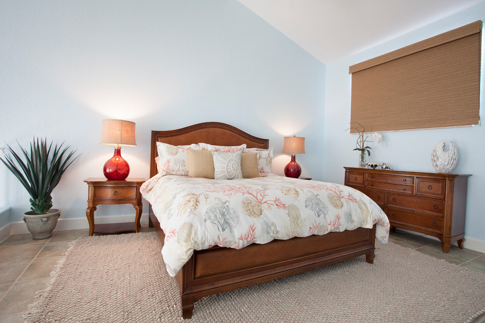 Foto de dormitorio principal costero grande sin chimenea con paredes azules y suelo beige