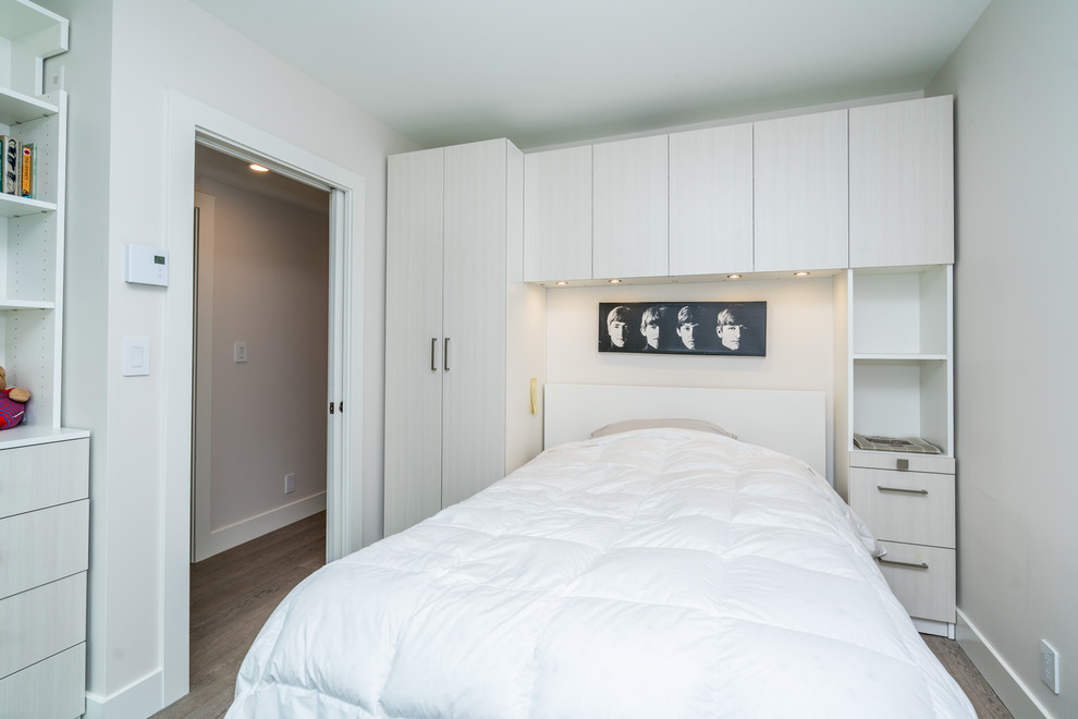 Mittelgroßes Modernes Gästezimmer mit weißer Wandfarbe, braunem Holzboden und grauem Boden in Vancouver