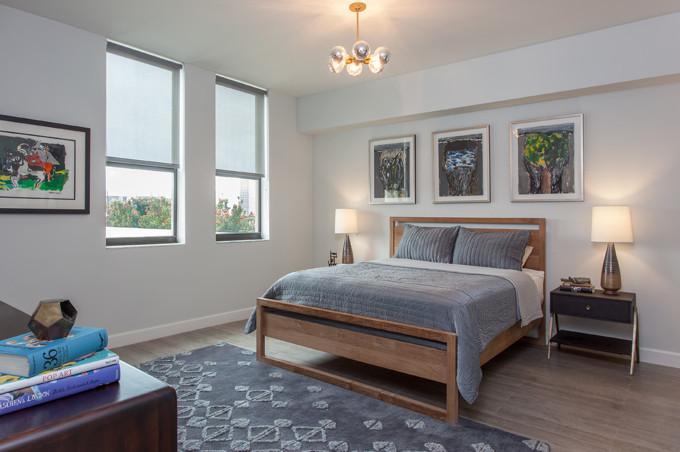 Modelo de dormitorio contemporáneo con paredes grises y suelo de madera en tonos medios