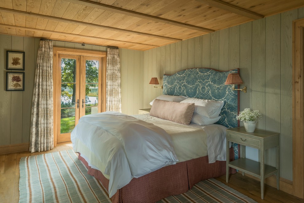 Diseño de dormitorio principal rural grande con paredes grises, suelo de madera clara y suelo marrón