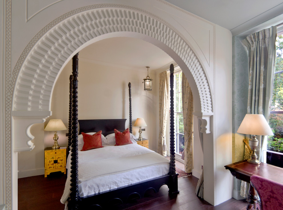 Mediterranes Schlafzimmer mit beiger Wandfarbe und dunklem Holzboden in London