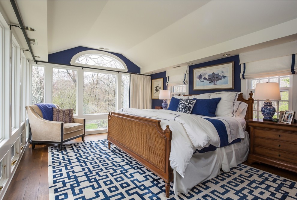 Mittelgroßes Country Hauptschlafzimmer mit blauer Wandfarbe, dunklem Holzboden und braunem Boden in New York