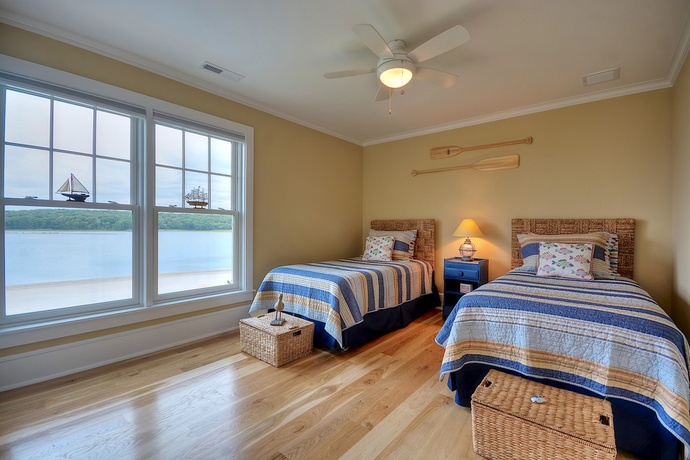 Diseño de habitación de invitados marinera de tamaño medio con paredes beige, suelo de madera clara y suelo beige