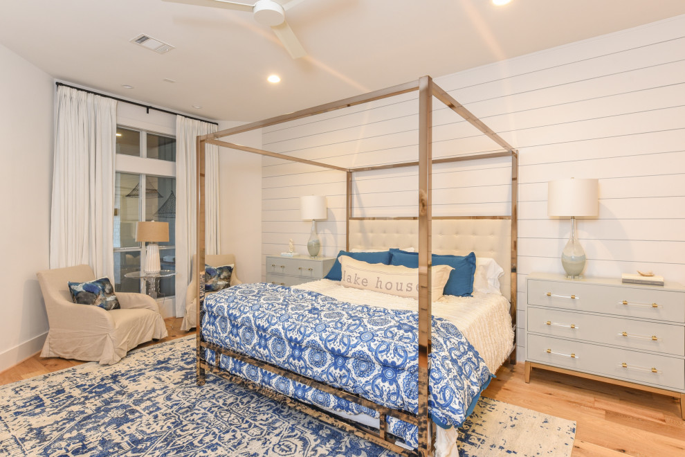 ダラスにあるビーチスタイルのおしゃれな寝室 (白い壁、無垢フローリング、茶色い床、塗装板張りの壁) のインテリア