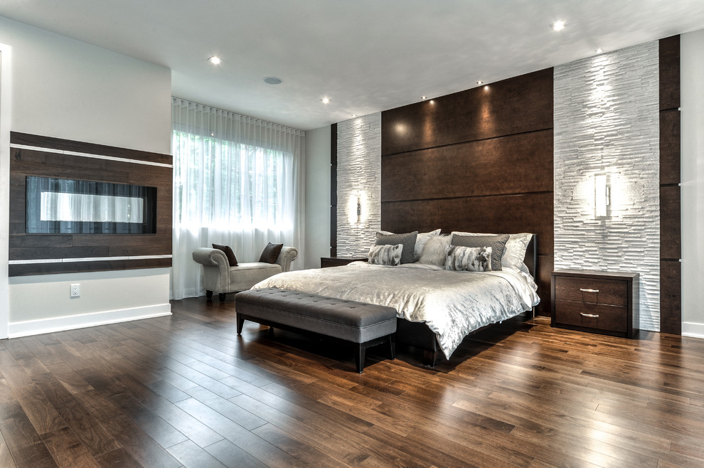Diseño de dormitorio principal minimalista extra grande con todas las chimeneas y marco de chimenea de madera