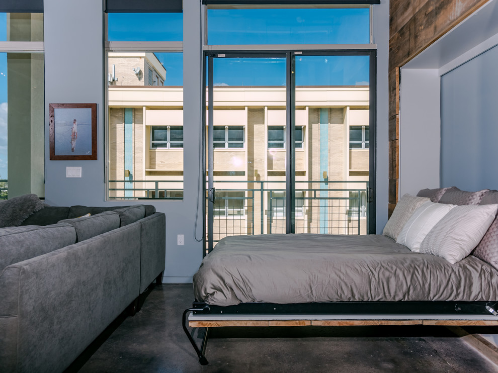 Ejemplo de dormitorio industrial con paredes grises, suelo de cemento y suelo gris