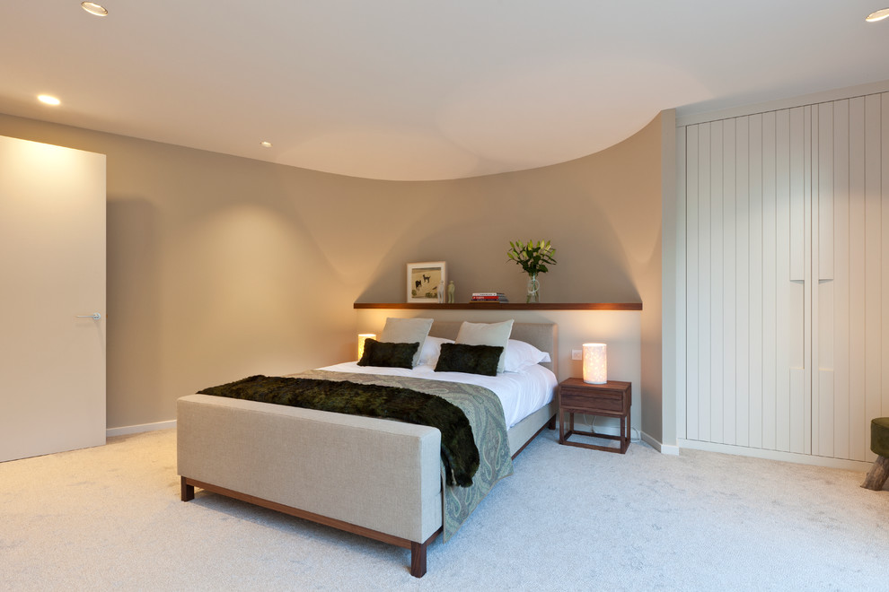 Photo of a contemporary bedroom in London with grey walls, carpet and no fireplace.