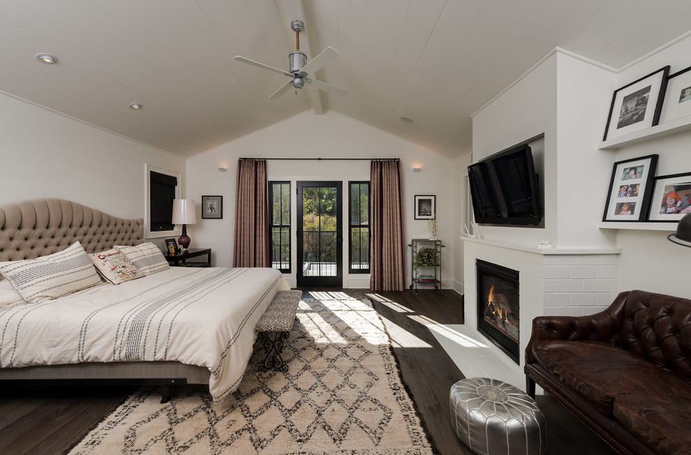 Inspiration for a large contemporary master bedroom in Los Angeles with white walls, dark hardwood flooring, a standard fireplace, a brick fireplace surround and brown floors.