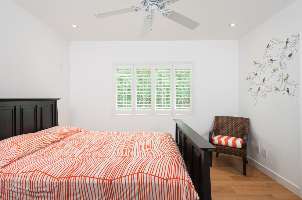 На фото: гостевая спальня среднего размера, (комната для гостей) в современном стиле с белыми стенами, паркетным полом среднего тона и коричневым полом без камина