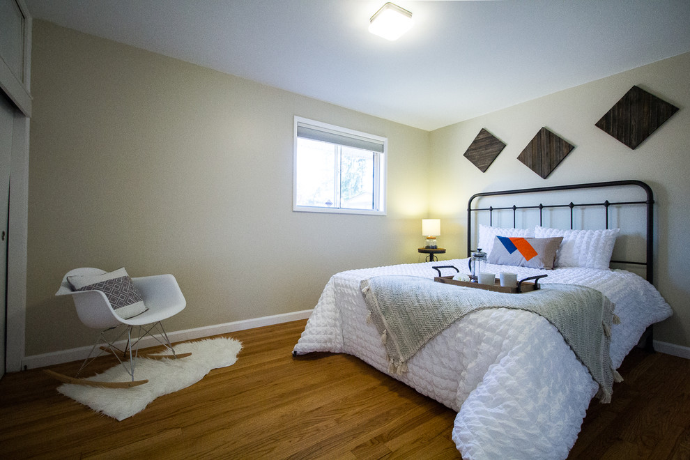 Imagen de habitación de invitados contemporánea pequeña sin chimenea con paredes beige, suelo de madera en tonos medios y suelo beige