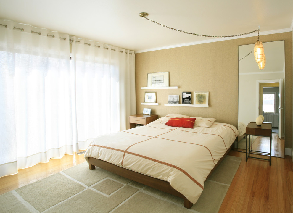 Réalisation d'une chambre design avec un mur beige et un sol en bois brun.