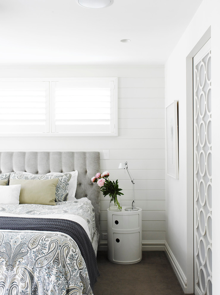 Imagen de dormitorio contemporáneo con paredes blancas y moqueta